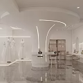 Elegant Bridal Shop Displaying Wedding Dresses On Central Stand With Floral Decor And Bright Lights