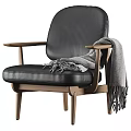 Brown Leather Armchair With Wooden Arms And Gray Throw Blanket