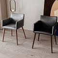 Gray and Black Leather Dining Chairs with Armrests and Wooden Legs in Modern Room Setting