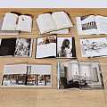 Open Books and Magazines with Black and White Photos and Interior Images on Wooden Floor