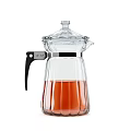 Transparent Glass Kitchen Kettle With Black Handle And Orange Liquid Inside