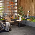 Indoor Landscape Design With Lattice Screen Wooden Wall Greenery Water Feature And Rattan Seating Area