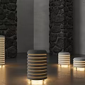 Illuminated Cylindrical Striped Floor Lamps In Modern Indoor Space With Stone Walls