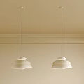 Two White Minimalist Pendant Lights in Beige Interior with Ceiling Molding and Simple Design
