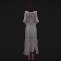Woman in light colored long dress wearing glasses with hands crossed standing against black background