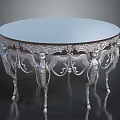 Round Silver Table With Ornate Carved Design And Angelic Figure Legs For Elegant Home Decor