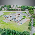 Aerial View of Building Complex with Green Spaces Trees Parking Areas Roads and Children's Playground