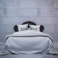 Double Bed with Dark Headboard Light Sheets and Pillows in Minimalist Gray Room