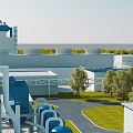 Modern Industrial Factory With Blue Cooling Towers Green Lawns Trees And Pipelines