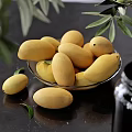 Fresh Yellow Mangoes in Glass Bowl with Green Leaves on Black Background