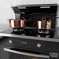 Sleek Black Integrated Kitchen Stove With Copper Pots And Oven Roasting Chicken On Gray Countertop