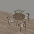 Round Wooden Dining Table With Upholstered Chairs And Green Plant Decor