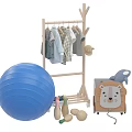 Children's Casual Clothes on Wooden Clothes Rack with Blue Exercise Ball and Lion Toy Box