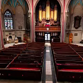 European Architecture Church Interior With Wooden Benches Pipe Organ And Stained Glass Windows