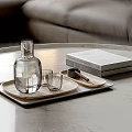 Modern Glass Cups On Tray With Books And Clear Bottle On Marble Tabletop