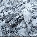 Scenic Snowy Mountain Terrain With Snow Covered Rocks And Evergreen Trees