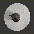 Red Carved Teapot Sculpture With Handle And Spout On White Circular Cloth