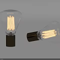 Vintage Clear Glass Light Bulbs With Filaments And Dark Bases Standing Tilted On Gray Background