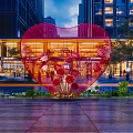 Heart Shaped Red Inflatable Decoration In Outdoor Square With Modern Buildings And Flowers