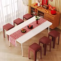 Six Red Stools Around White Table With Red Table Runner Fruit And Vase