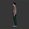 A Man Wearing Colorful Patterned T-Shirt Green Pants And Blue Shoes Against Gray Background