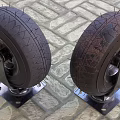 Heavy Duty Industrial Tires Mounted on Metal Brackets with Wheels on Brick Pavement