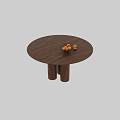 Round Wooden Dining Table With Three Legs And Metal Fruit Basket With Oranges