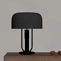 Black Table Lamp With Gold Base And Stand On Wooden Table With Red Fruits