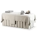 Comfortable Massage Bed With White Linen Stacked Towels And Side Table With Candles