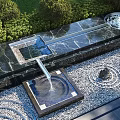 Garden Ornamental Water Feature With Marble Countertop Fountain Pebble Stone Floor And Trimmed Green Shrubs