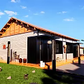 Rustic Guesthouse Building With Wooden Roof Stone Walls Front Porch Clay Pots Purple Flowers