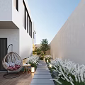 Courtyard Garden With White Walls Stone Path Wicker Swing Chair And White Plants