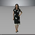 Woman in Green Dress With White Floral Patterns And Lace Hem Standing Against Gray Background