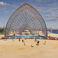Scenic Waterfront Landscape With Arched Structures Palm Trees And Public Leisure Activities