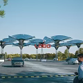 Contemporary Entrance Gate With Solar Panel Canopies Red Signage And Moving Vehicles