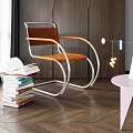 Modern Leisure Chair with Brown Seat Metal Frame near Stack of Books and Pink Table