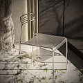 Sleek Metal Frame Leisure Chairs By Stone Wall With Plant And Shadows
