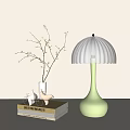 Light Green Table Lamp With White Pleated Shade Near Books And Vase With Twigs