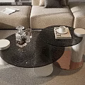 Elegant Black Glass Coffee Table With Cylindrical Legs And Decorative Glassware