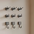Modern Black Wall Hooks With Different Designs On Beige Wall For Home Decor