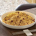 Yellow Noodles with Red Granules Served in White Bowl on Wooden Table and Chopsticks