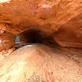Red Rock Cave Interior With Natural Arch Gravel Floor And Entrance Light