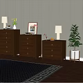 Three Wooden Chests of Drawers with Table Lamps Vases and Green Plant on Wooden Floor