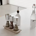 Kitchen Countertop Setup With Silver Pepper Grinders Wooden Tray Oil And Water Bottles