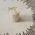 White Round Bedside Table With Drawers Glass Vase And Yellow Flowers On Light Colored Carpet