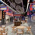 Vibrant Commercial Street With Neon Signs Shops Tables Chairs And Decorative Lights