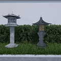 Traditional Japanese Stone Lanterns As Garden Ornaments With Green Shrubs Grass And Stone Pathway