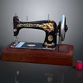 Vintage Sewing Machine With Black Body Golden Patterns Wooden Base And Red Thread Spool