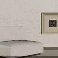 Beige Single Sofa With Cushion Against Textured Wall And Beige Framed Painting