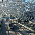 Modern Arch Shaped Road Infrastructure With Transparent Roof Metal Framework And Vehicles